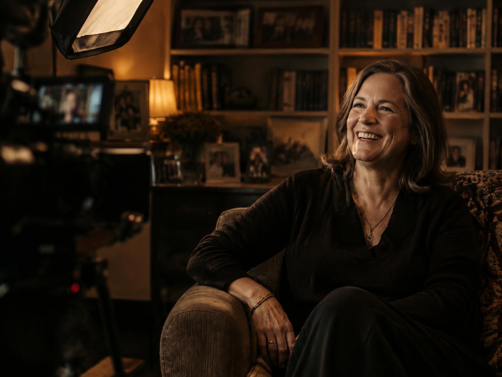 A woman in her fifties laughing during an at-home interview